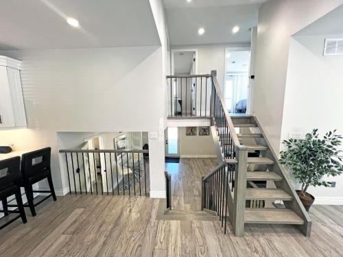 a staircase in a living room with a table at Luxe Home Near Limeridge - Sleeps 11 - Pool in Hamilton