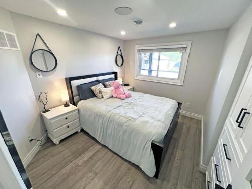 a bedroom with a pink teddy bear sitting on a bed at Luxe Home Near Limeridge - Sleeps 11 - Pool in Hamilton