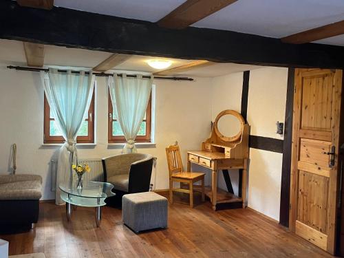 a living room with a table and a desk at Fachwerk in Bergfreiheit in Bad Wildungen