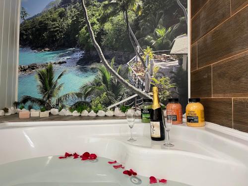 a bath tub with two wine glasses and a window at Fonte Retreat Premium Suite in Sandim