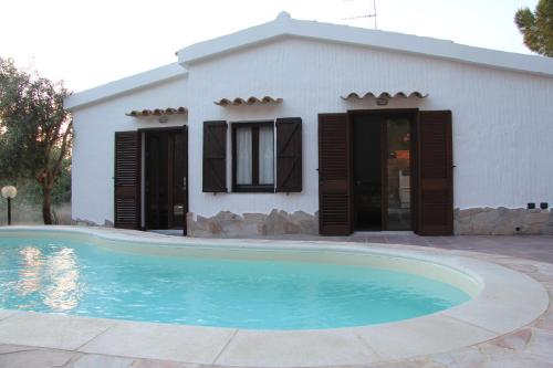 a house with a swimming pool in front of a house at Almà in Torre delle Stelle