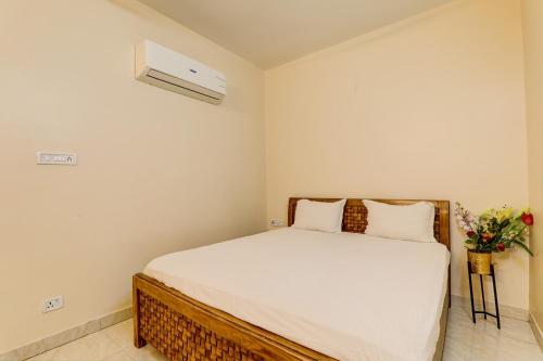 OYO Hotel Umrao في باتنا: غرفة نوم بسرير مع شراشف بيضاء وزهور