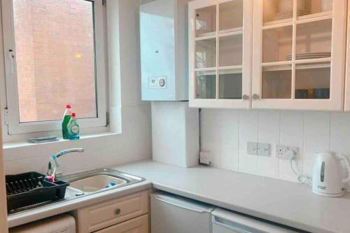 a kitchen with a sink and a window at Cosy flat in the Heart of Wandsworth in London