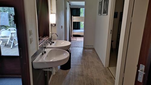杜廷赫姆的住宿－Groepsaccommodatie - De Ooymanhoeve，一间带两个盥洗盆和走廊的浴室