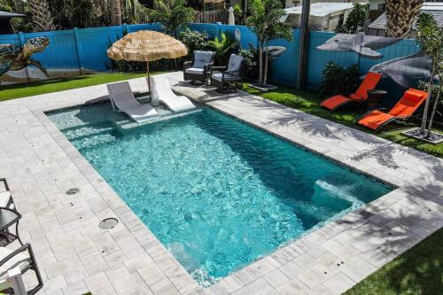 a swimming pool with chairs and an umbrella at Summer Rayne in Cocoa Beach