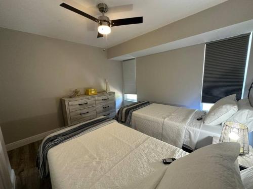 a bedroom with two beds and a ceiling fan at Backyard Oasis in Port Saint Lucie