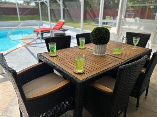 a wooden table with glasses and a potted plant on it at Backyard Oasis in Port Saint Lucie