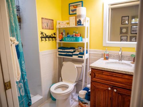 a bathroom with a toilet and a sink and a mirror at Summer Rayne in Cocoa Beach