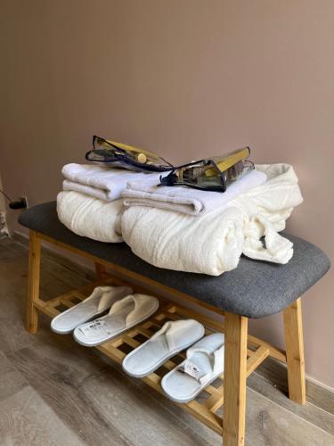 - une pile de serviettes et de chaussons sur une table dans l'établissement IS ROOM, à Bouafle