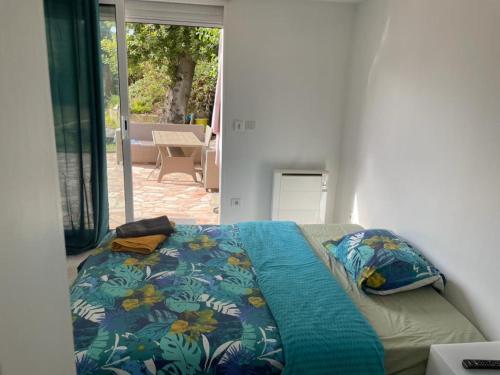 ein Schlafzimmer mit einem Bett mit einer blauen Decke darauf in der Unterkunft Studio proche PARIS-orly in Sainte-Geneviève-des-Bois