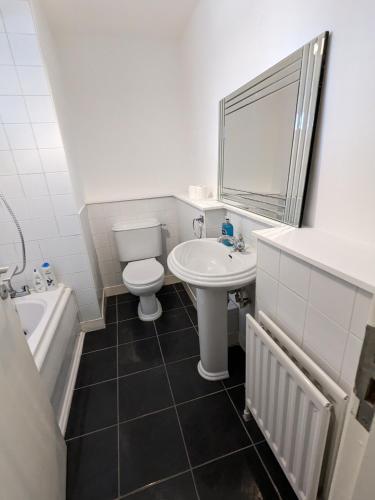 a bathroom with a sink and a toilet and a tub at Best Location in Belfast! Free parking in Belfast