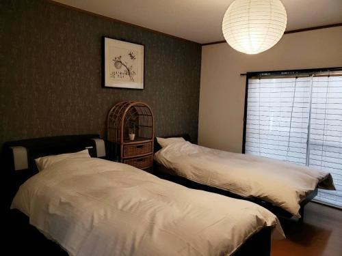 1 dormitorio con 2 camas, espejo y ventana en 竹の宿, 
