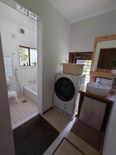 a bathroom with a washing machine and a sink at 竹の宿 in Nagao