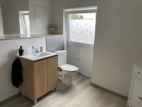 a bathroom with a white toilet and a sink at Maison/appartement de campagne in Champvans