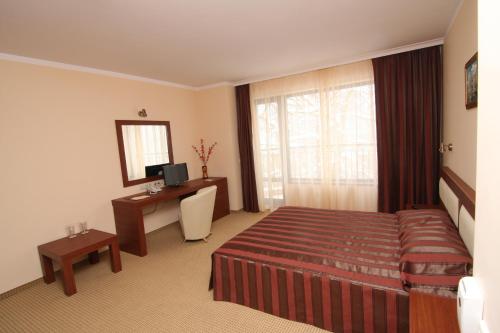 a hotel room with a bed and a desk at SPA Hotel Medicus in Varshets