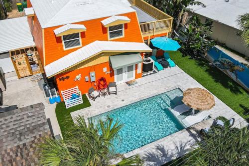 an orange house with a swimming pool in front of a house at Summer Rayne in Cocoa Beach