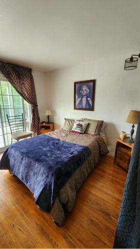 um quarto com uma cama grande e um cobertor azul em 2nd floor Room w Private Facilities Deck Views of Golden Gate Forest Tamalpais Valley WIFI Cable TV em Mill Valley