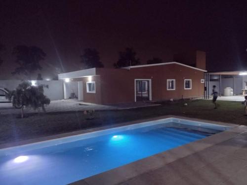 - une piscine en face d'une maison la nuit dans l'établissement Complejo Bru-Mar, 