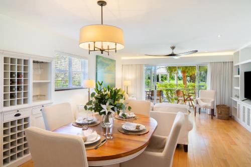 a dining room with a table and white chairs at 10 The Enclave in Providenciales