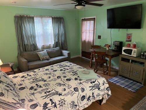 a bedroom with a bed and a table with a couch at Boat House Studio - Water Front Pets WiFi Smart TV apts in Norfolk