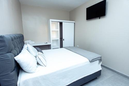 1 dormitorio con cama, sofá y TV en Suites Gonzalez, suite 4, en Ciudad Juárez