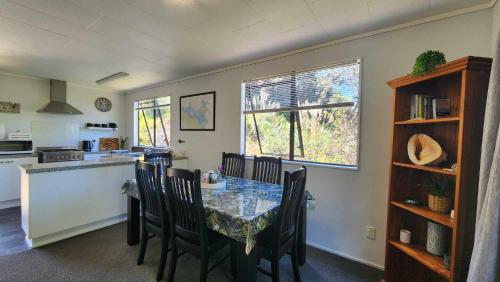 a kitchen and dining room with a table and chairs at Beach House Matauri Bay in Matauri Bay