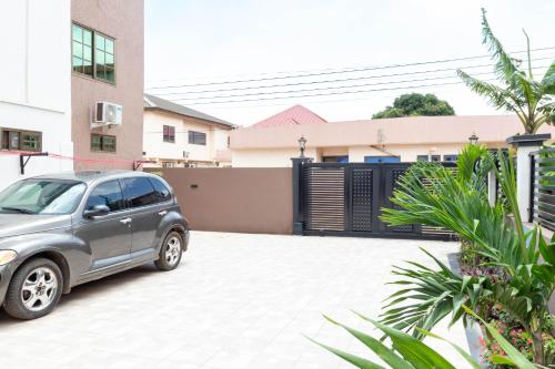 a car parked in a parking lot in front of a house at Richie's Appartments in Accra