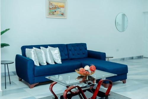 a living room with a blue couch and a table at Richie's Appartments in Accra