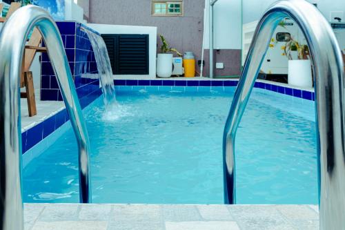 a swimming pool with two water slides in it at Richie's Appartments in Accra