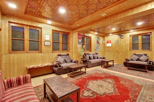 una sala de estar con sofás, mesas y ventanas en Hotel Ab-i-Hayat, en Srinagar
