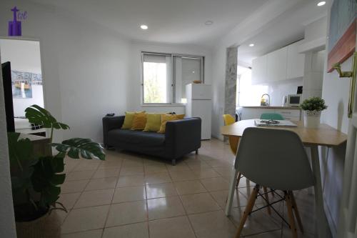 a living room and kitchen with a couch and a table at Lisbon South Apartment in Lisbon