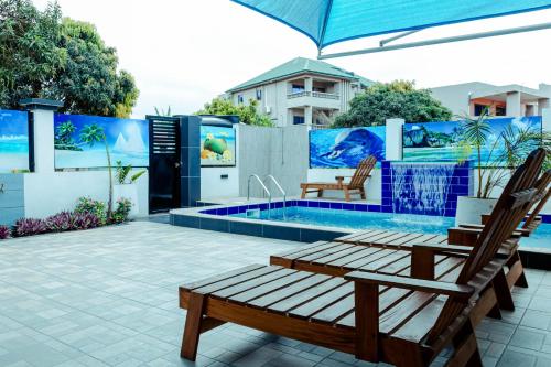 a patio with two chairs and a swimming pool at Richie's Appartments in Accra