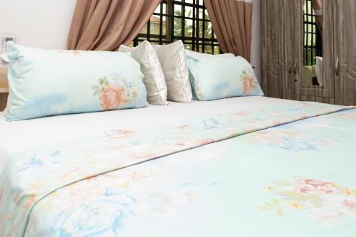 a bed with blue and white sheets and pillows at Richie's Appartments in Accra