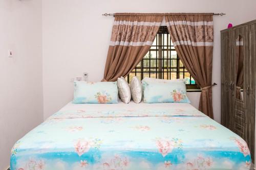 a bedroom with a large bed with a window at Richie's Appartments in Accra