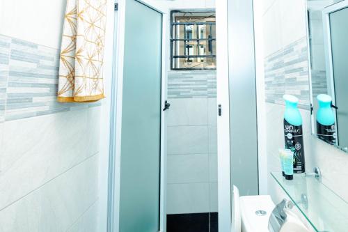a bathroom with a shower and a toilet and a sink at Richie's Appartments in Accra