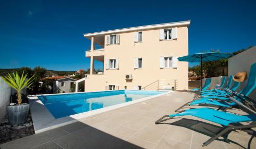 a villa with a swimming pool in front of a building at Apartments Villa Laguna with pool in Ražanj