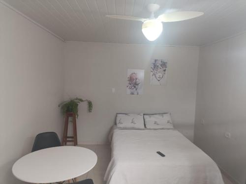 a white room with a bed and a table at Pousada 12 Ilhas in Pontal do Paraná