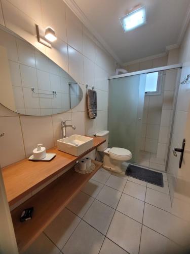 ein Bad mit einer Dusche, einem Waschbecken und einem WC in der Unterkunft Nosso Ap em Bento in Bento Gonçalves