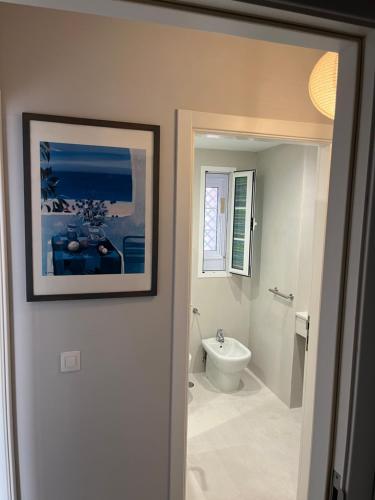 a bathroom with a toilet and a picture on the wall at Playa del Duque-Amazing views 2 bedroom in Adeje