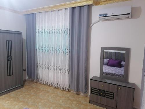 a living room with a television and a bed at Yaso Roof & Apartments in Amman