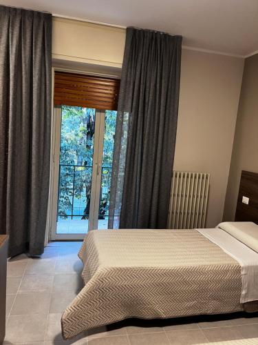 a bedroom with a bed and a large window at Bella Napoli albergo Chiari in Chiari