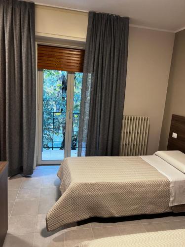 a bedroom with a bed and a large window at Bella Napoli albergo Chiari in Chiari