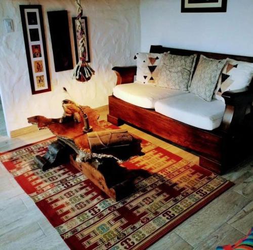 een woonkamer met een bed, een tafel en een tapijt bij San Joaquín Hospedaje Campestre in Belén de Umbría