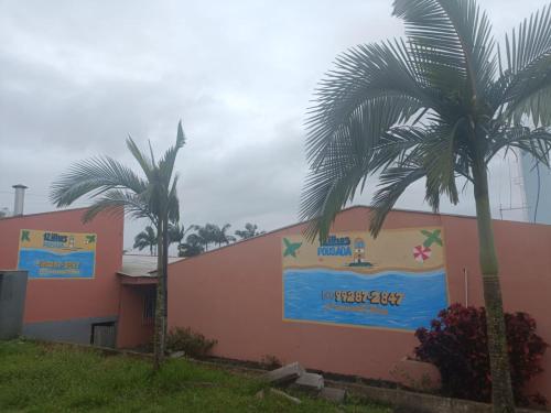 two palm trees in front of a building at Pousada 12 Ilhas in Pontal do Paraná