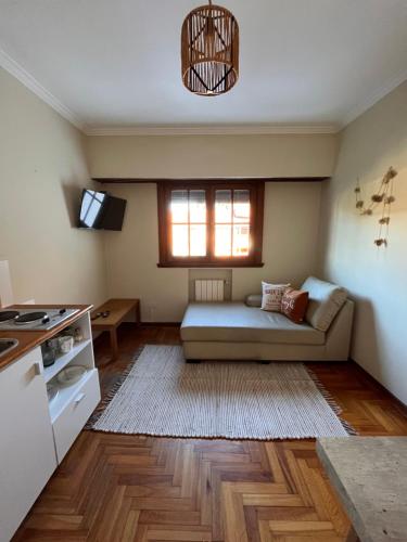 sala de estar con sofá y ventana en Deptos Punto Rivas Barrio Los Troncos en Mar del Plata