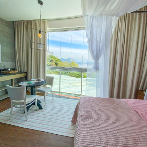 a bedroom with a bed and a table and chairs at Rio Holiday Boutique Hotel in Niterói