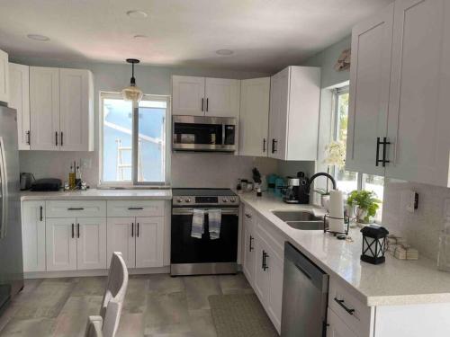 a kitchen with white cabinets and a sink at key Deer Retreat/direct gulf access/hot tub in Big Pine Key