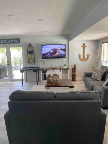 a living room with a couch and a flat screen tv at key Deer Retreat/direct gulf access/hot tub in Big Pine Key