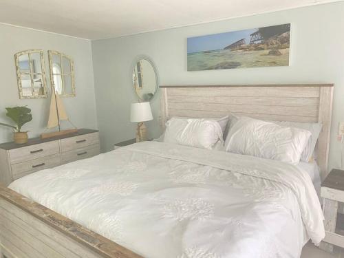 a bedroom with a large white bed with two mirrors at key Deer Retreat/direct gulf access/hot tub in Big Pine Key