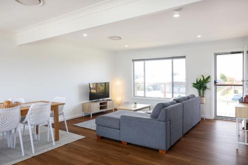 a living room with a couch and a table at Coastal Breeze - 67 Burrill Street in Ulladulla